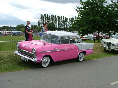 2001 Ford Fiesta - A two-tone classic sedan is displayed outdoors with spectators and other vehicles in the background.