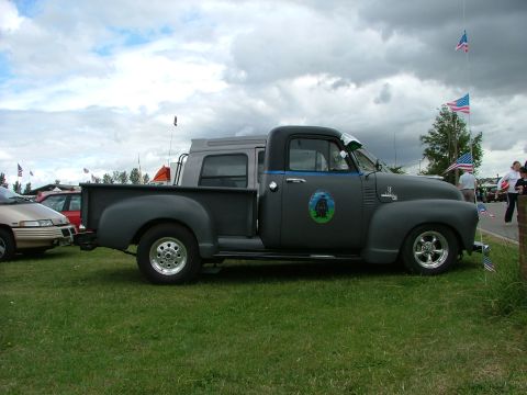 2001 Ford Fiesta - A classic pickup truck is parked on grass with other vehicles and American flags in the background.