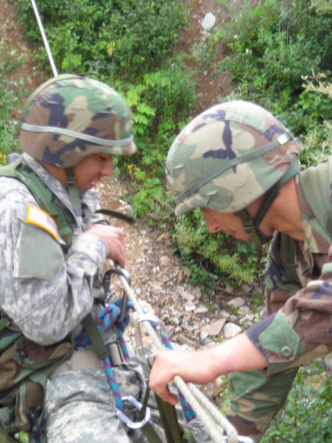 2003 Jeep TJ - Soldiers in camouflage gear are seen preparing ropes for a rappelling exercise in a , outdoor environment.