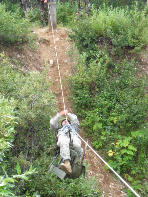2003 Jeep TJ - Military personnel descend a steep, vegetated incline during a training exercise.
