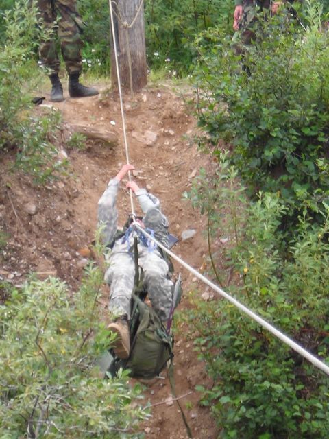 2003 Jeep TJ - Soldiers practice rappelling down a steep, wooded incline using a rope and harness system.