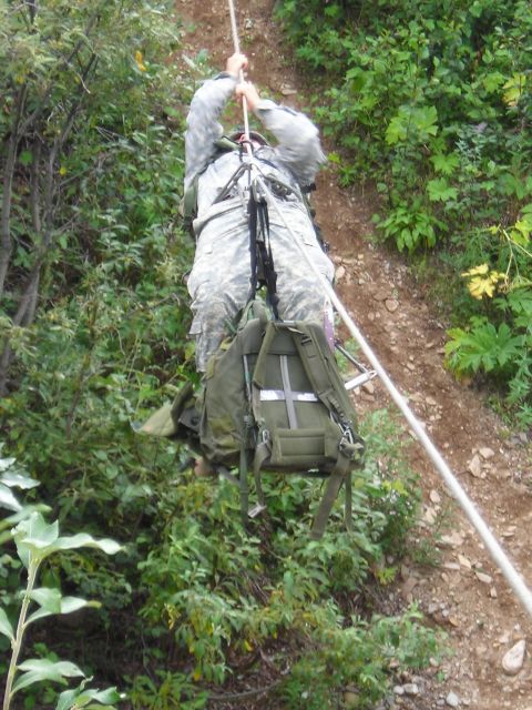 2003 Jeep TJ - A soldier uses a rope to descend a , vegetated hillside during what appears to be a training exercise.