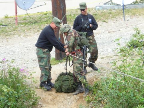 2003 Jeep TJ - Military personnel are engaged in an activity involving ropes and equipment outdoors, with a satellite dish visible in the background.