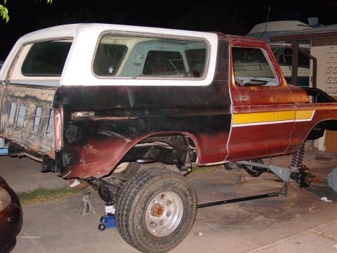 1979 Ford Bronco - Ford Bronco undergoing restoration, with suspension components exposed and body panels removed.