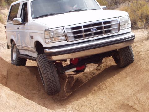 1993 Ford Bronco - This Ford Bronco is navigating a steep dirt incline, its off-road capabilities.