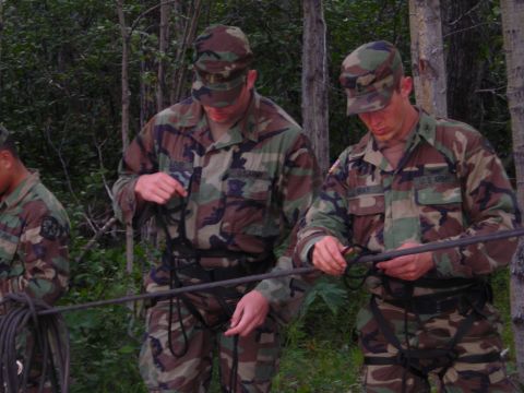 2003 Jeep TJ - Soldiers practice knot tying with ropes in a wooded area, likely during a training exercise.