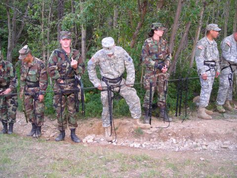 2003 Jeep TJ - A group of soldiers in camouflage uniforms stand in a line outdoors, with trees in the background.
