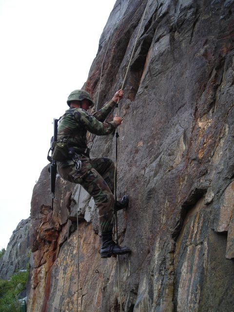 2003 Jeep TJ - A soldier uses ropes to descend a steep rock formation during training.