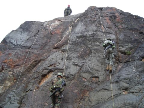 2003 Jeep TJ - Military personnel descend a steep rock formation using ropes and harnesses.