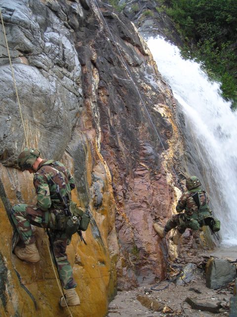 2003 Jeep TJ - Soldiers practice rappelling down a steep, wet rock face beside a cascading waterfall.