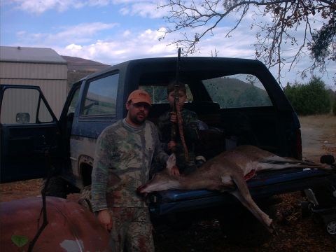 1985 Ford Bronco - A man and a boy pose with a deer and rifles next to an SUV after a hunt.