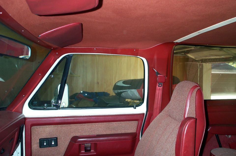 Red interior with patterned seats and door panel, visible sun visors