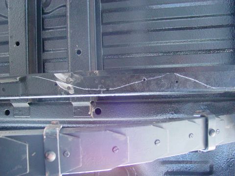 1979 Ford Bronco - Undercarriage view showing frame rails and suspension components with chalk markings.