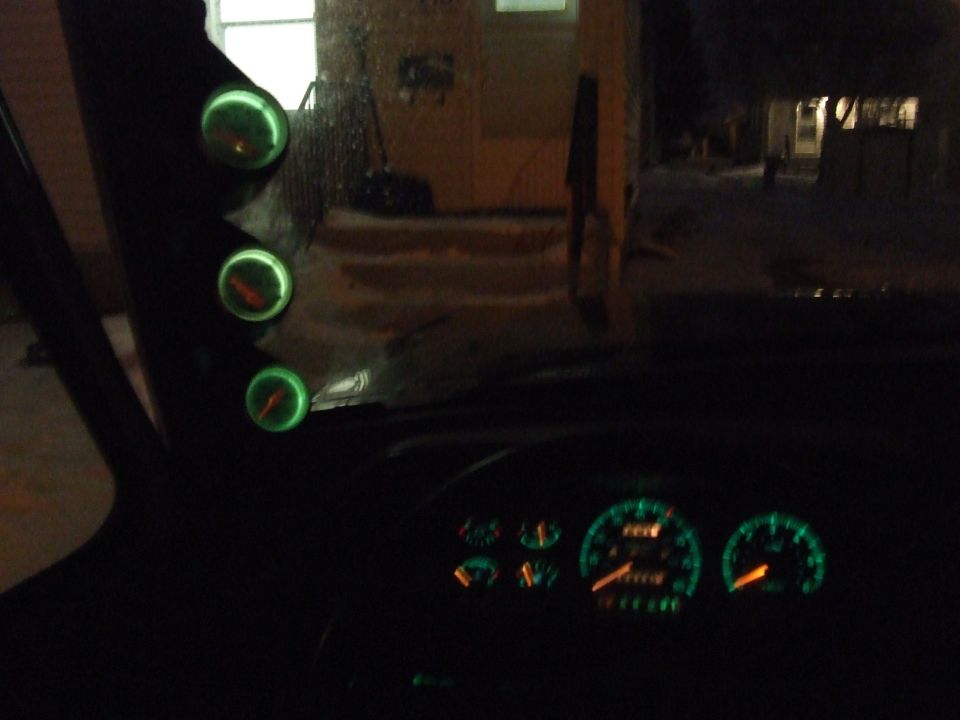 Interior view of custom gauge pod with three glowing green gauges and dashboard gauges
