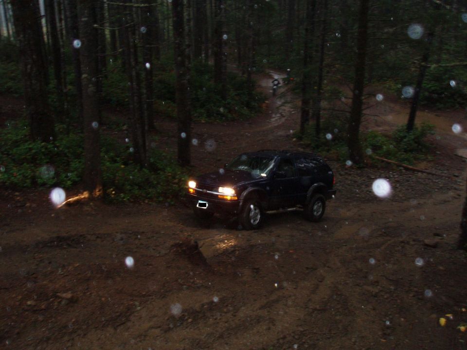 Dark 1995 Ford Bronco on a muddy forest trail