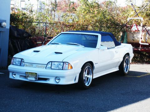 2001 Mercury Grand Marquis - White convertible with hood scoops and chrome wheels, likely a 1990s Ford Mustang.