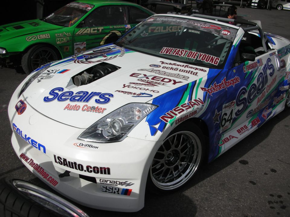 White and blue drift Nissan covered in Sears Auto Center and sponsor decals, number 64
