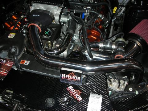 1998 Ford Crown Victoria - engine bay shows polished intercooler piping and Hellion-branded turbo plumbing over a carbon-fiber panel.