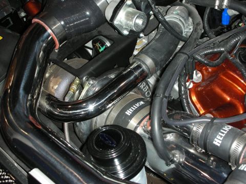 1998 Ford Crown Victoria - Polished and black turbo charge pipes with Hellion-branded couplers wind through a detailed engine bay.