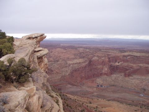 1993 Ford Bronco - A wide desert canyon vista with rock formations and distant mesas under an overcast sky.