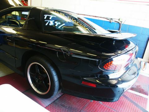 2001 Mercury Grand Marquis - A black Pontiac Firebird Trans Am is positioned on a dynamometer, ready for testing.