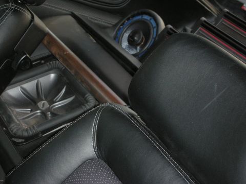 1998 Ford Crown Victoria - Custom car interior showing black leather seats with contrast stitching, a wood trim panel, a subwoofer enclosure, and a blue-trimmed speak…