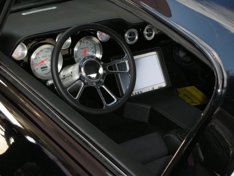 1998 Ford Crown Victoria - Interior view through a side window of a custom dash with chrome-rimmed analog gauges, a billet steering wheel, and a flip-up display scree…