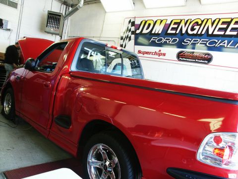 2001 Mercury Grand Marquis - A red 2001 Ford F-150 SVT Lightning pickup truck is shown in a garage with the hood open.