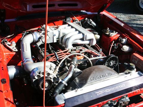 2001 Mercury Grand Marquis - Close-up view of a modified engine bay a supercharger and prominent red wiring, with caution and brand text visible on components.