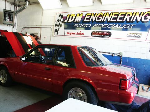 2001 Mercury Grand Marquis - Red coupe with hood open inside a garage a JDM Engineering banner.