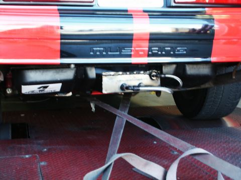 2001 Mercury Grand Marquis - Rear view of a car with custom stripes and exhaust modifications, secured on a trailer for transport.