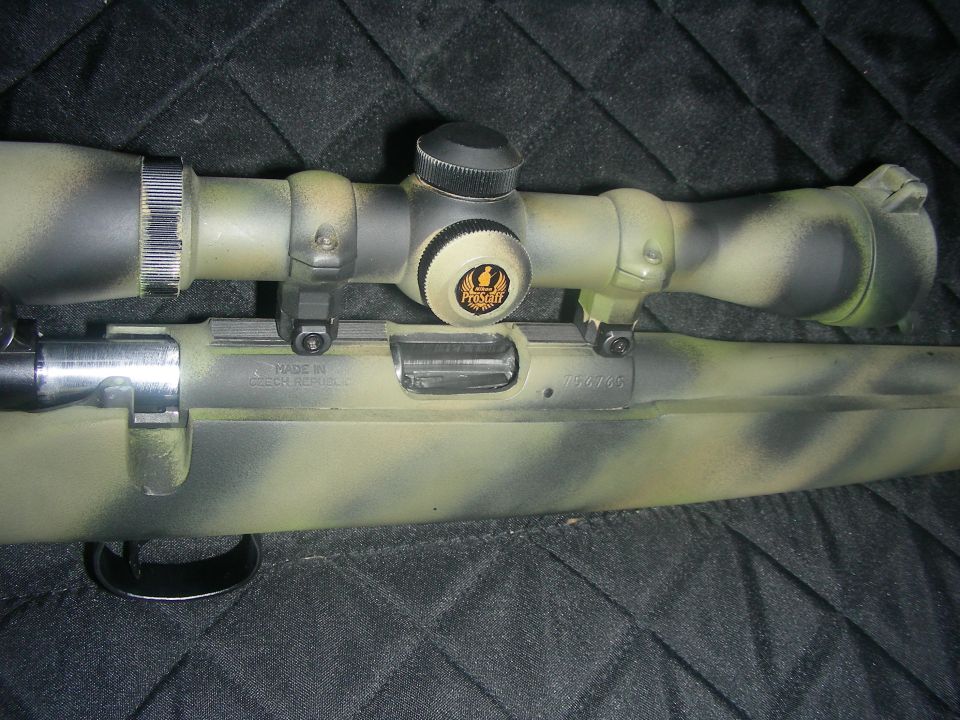 Camouflaged rifle with scope, showing "MADE IN CZECH REPUBLIC" text