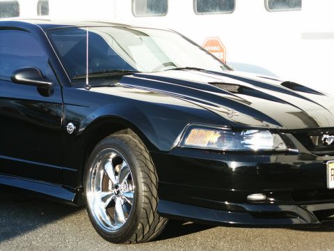 2001 Mercury Grand Marquis - A black 2001 Ford Mustang GT coupe is shown with chrome wheels and a prominent hood scoop.