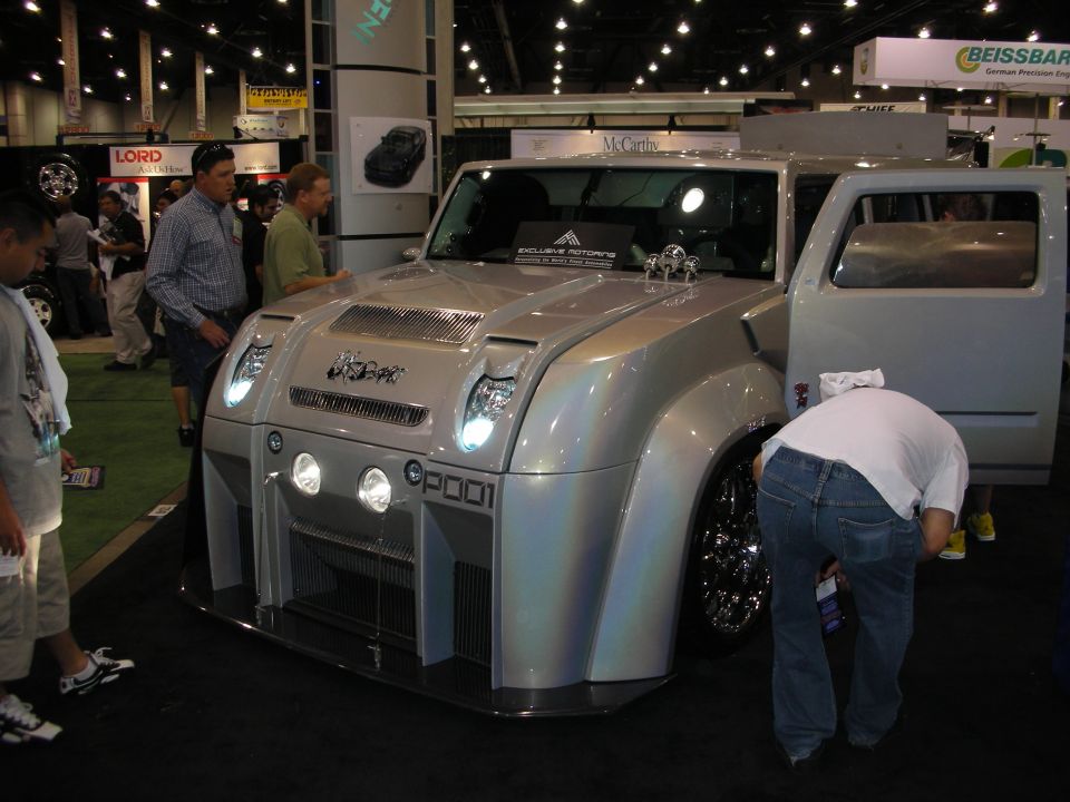 Silver custom retro-styled SUV concept vehicle on display at indoor trade show