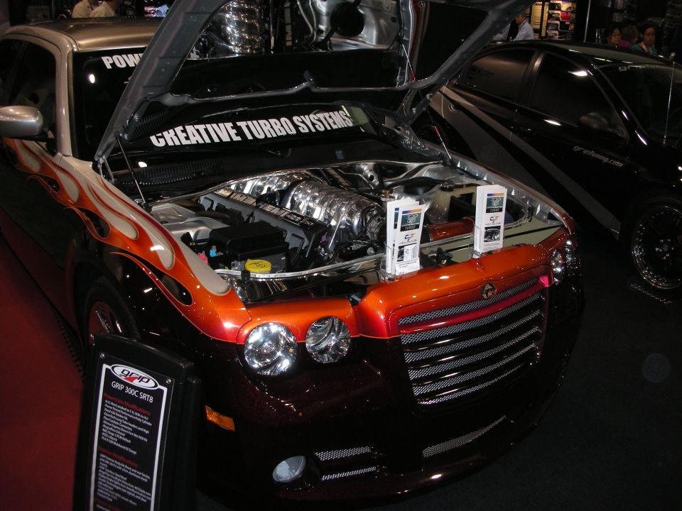 Engine bay of Dodge sedan with flame paint and 'Creative Turbo Systems' banner