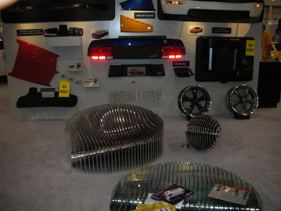 Trade show display wall of car body panels, taillights and polished wheels