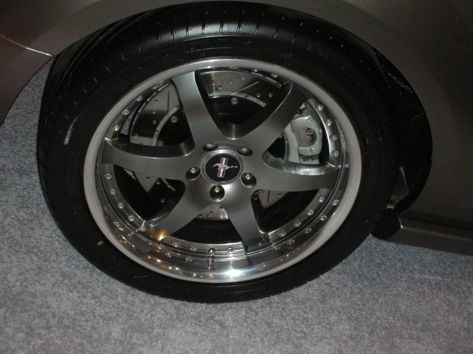 Close-up of gunmetal five-spoke wheel with polished lip on a Ford vehicle
