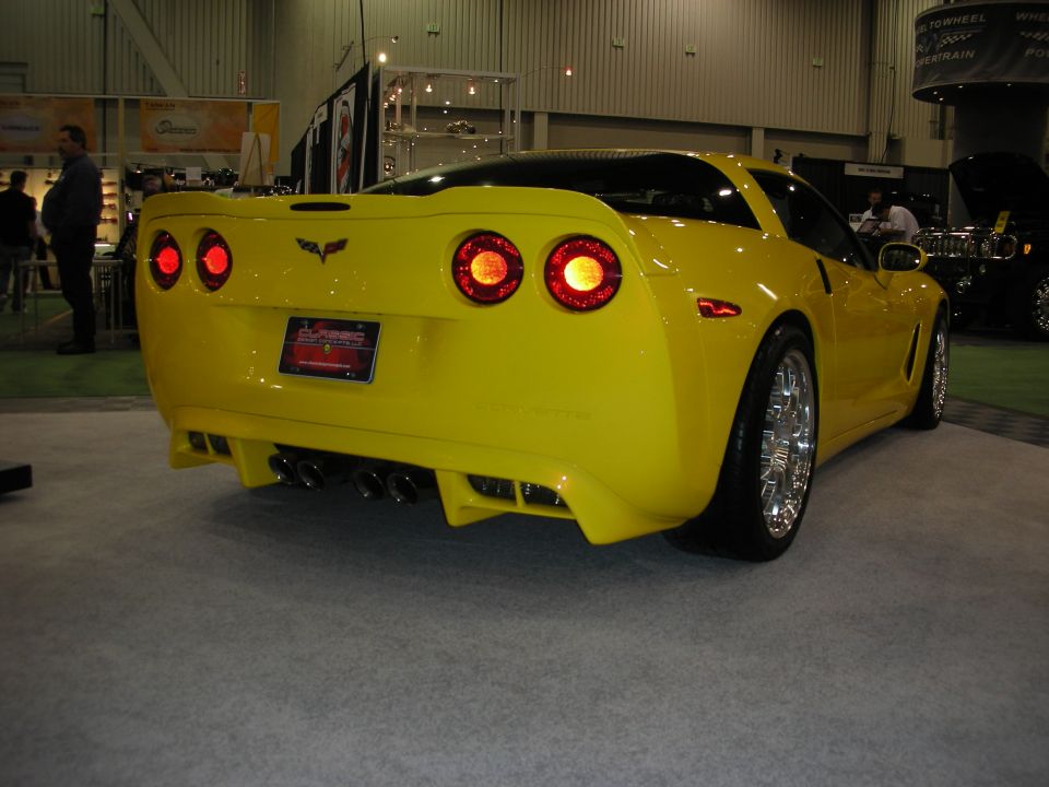 Rear three-quarter of yellow C6 Chevrolet Corvette with quad exhaust at car show