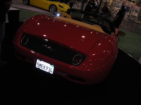 1998 Ford Crown Victoria - Rear view of a red convertible roadster bearing California license plate '5MEK934', with a yellow sports car visible behind it.