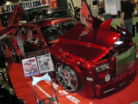 1998 Ford Crown Victoria - candy-red 'Nokturnal' custom Rolls-Royce Phantom with vertical doors, spec placards and big chrome wheels at the JT Autostyle booth.
