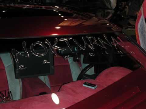 1998 Ford Crown Victoria - Custom dark-red show car interior with chrome 'NOKTURNAL' lettering under the windshield, a flip-up monitor and red velour seats.