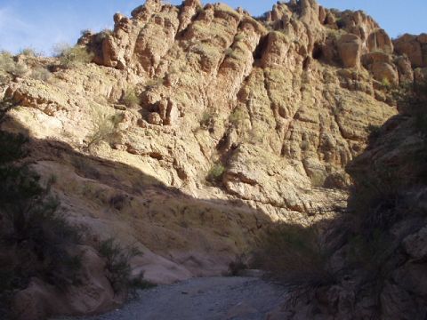 1993 Ford Bronco - A scenic view of a rocky canyon with a dirt road winding through it under a clear blue sky.