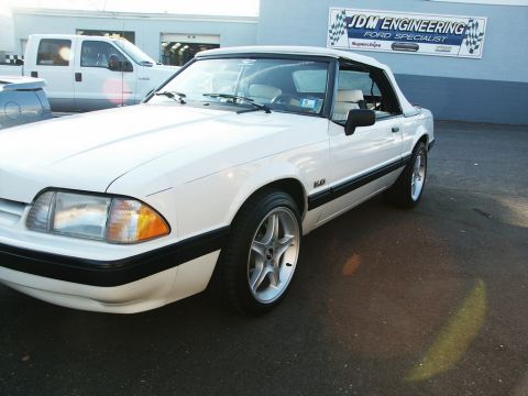 2001 Mercury Grand Marquis - White convertible sports car with 5.0 badge parked in front of JDM Engineering, a white pickup truck is visible behind it.