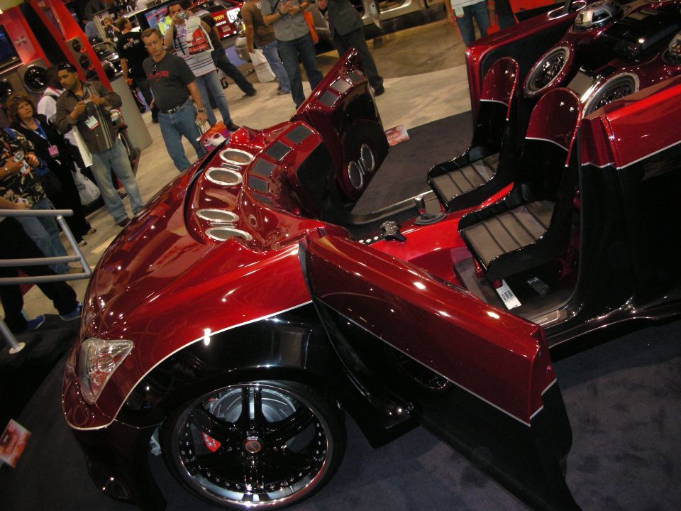 Candy-red custom car high angle showing open door and speaker pods
