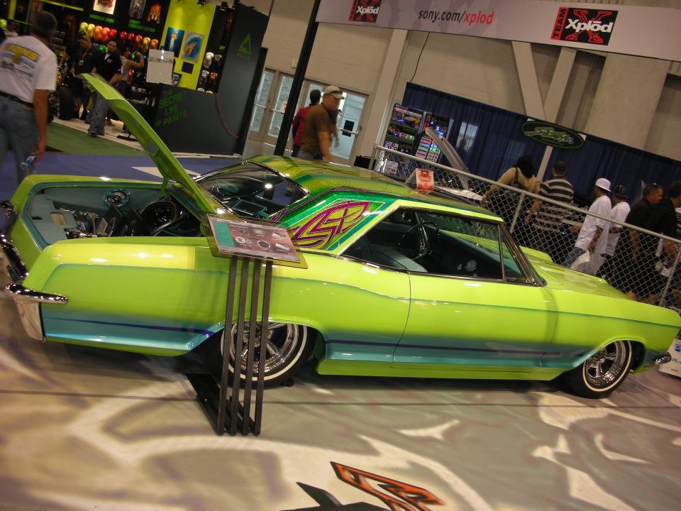 Lime-green lowered classic coupe with graphics on white show floor
