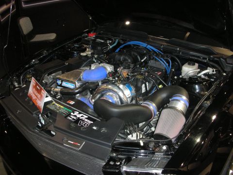 1998 Ford Crown Victoria - Detailed engine bay showing a supercharged V6 with polished blower, conical cold-air intake and blue ignition wires.