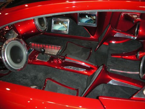 1998 Ford Crown Victoria - wild candy-red custom interior featuring built-in subwoofers, dual video screens, a sculpted center console and suede flooring.