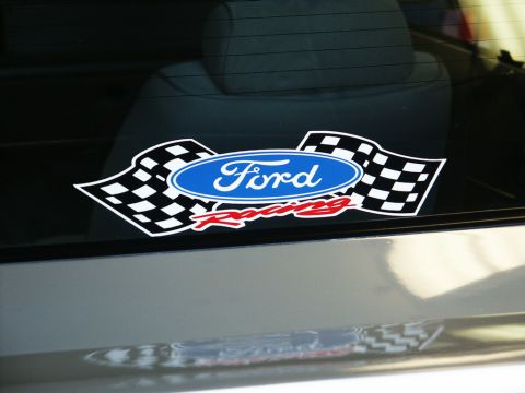 2001 Mercury Grand Marquis - A Ford Racing sticker adorns the rear window of a vehicle, checkered flags and the Ford logo.