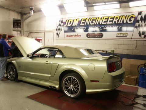 2001 Mercury Grand Marquis - A light green convertible Mustang is positioned on a dynamometer with its hood open, under the "JDM Engineering" sign.
