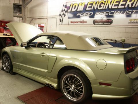 2001 Mercury Grand Marquis - Light green Ford Mustang convertible on a lift inside a garage with a "JDM Engineering Ford Specialist" banner on the wall.